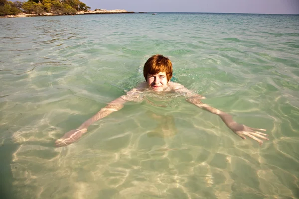 Garçon nageant dans le bel océan clair — Photo