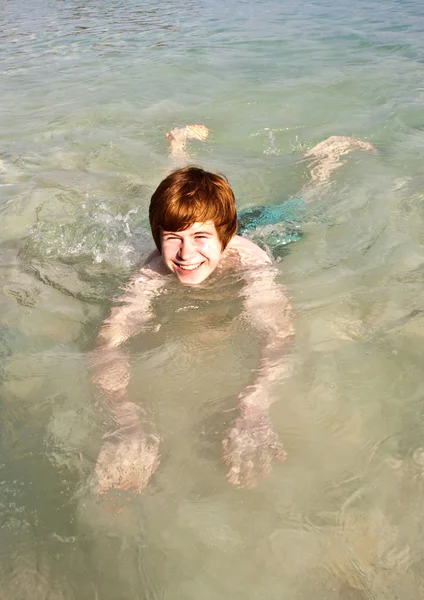 Junge schwimmt im schönen klaren Ozean — Stockfoto