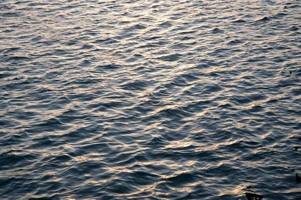 Water met gladde golven in zonsondergang — Stockfoto