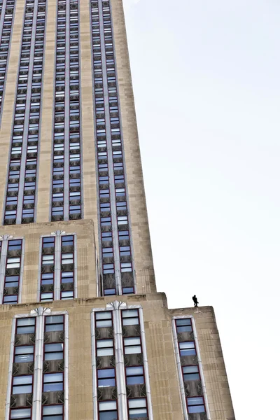 Fassade eines Wolkenkratzers mit Statue des Menschen — Stockfoto