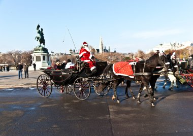 Driver of the fiaker is dressed as Santa Claus clipart