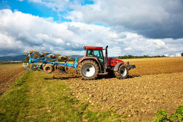 трактор с плугом на поле

