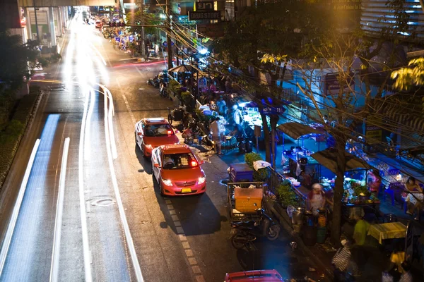 Wiązka światła w nocy z samochodów, które biegną wzdłuż głównej drogi przez n — Zdjęcie stockowe
