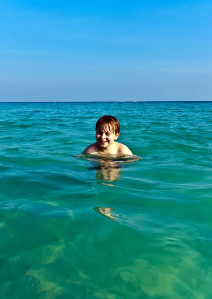 Αγόρι βρίσκεται σε σαφείς ζεστά θάλασσα — Φωτογραφία Αρχείου