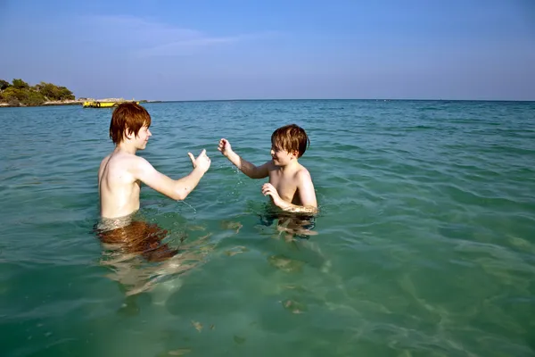 Los hermanos están disfrutando del agua tibia en la hermosa playa —  Fotos de Stock