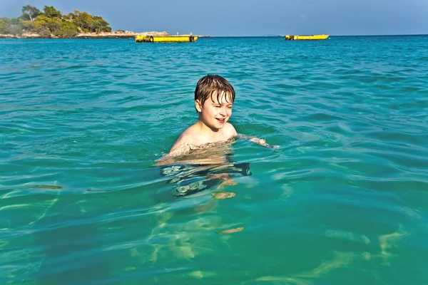 Хлопчик насолоджується чистим теплим морем — стокове фото