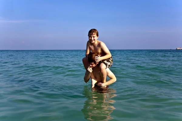 Brüder genießen das klare, warme Wasser am schönen Strand — Stockfoto