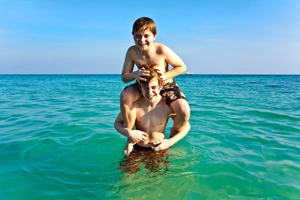 Bratři se těší jasné teplé vody na krásné pláži — Stock fotografie