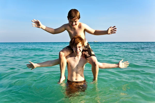 Los hermanos están disfrutando del agua tibia en la hermosa playa —  Fotos de Stock