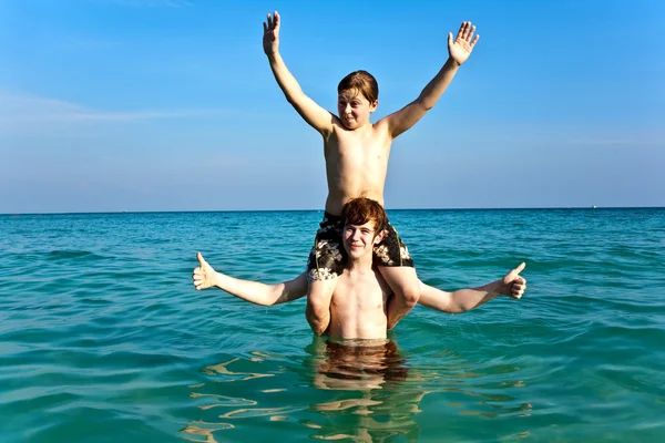 Broers zijn genieten van het duidelijk warm water op de prachtige beac — Stockfoto