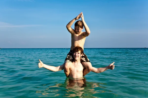 Fratelli stanno godendo l'acqua calda e limpida al bellissimo mare — Foto Stock