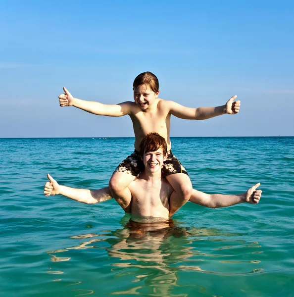 Los hermanos están disfrutando del agua tibia en la hermosa playa — Foto de Stock