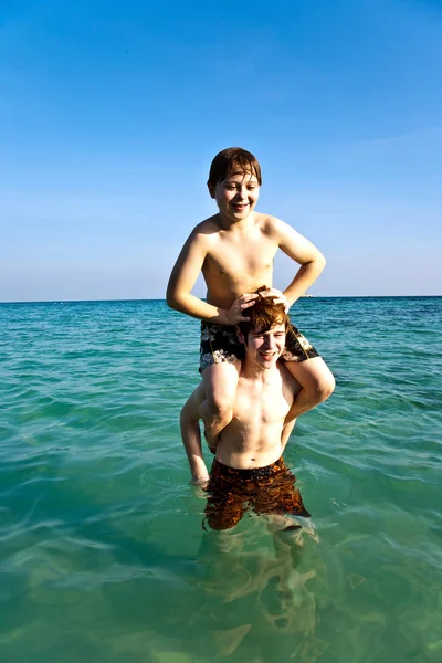 Los hermanos están disfrutando del agua tibia en la hermosa playa —  Fotos de Stock