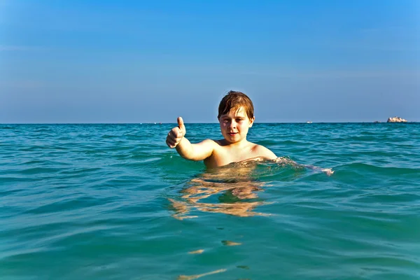 Pojke med rött hår njuter det klara, varma vattnet vid beauti — Stockfoto