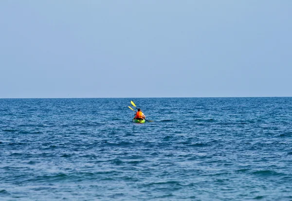Pai e filho estão remando com uma canoa em mar aberto — Fotografia de Stock