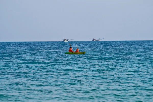 Pai e filho estão remando com uma canoa em mar aberto — Fotografia de Stock