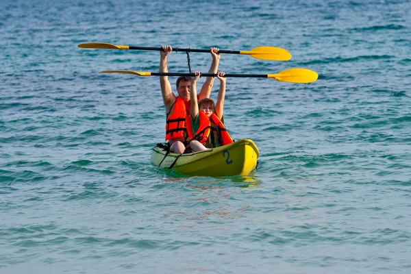 Otec a syn jsou padelling s kánoí na otevřeném moři — Stock fotografie