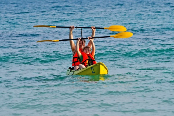 Père et fils padent avec un canot en pleine mer — Photo