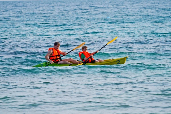 Padre e figlio sono padelling con una canoa in mare aperto — Foto Stock