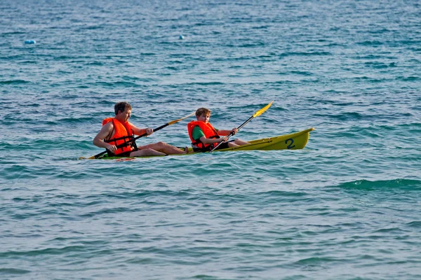Vader en zoon zijn padelling met een kano op open zee — Stockfoto