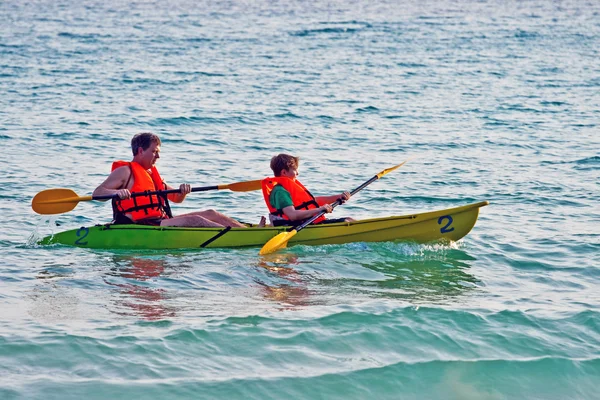 Padre e hijo están acolchados con una canoa en mar abierto — Foto de Stock