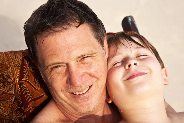 Отец обнимает своего счастливого улыбающегося сына — стоковое фото