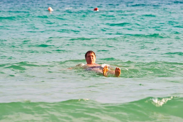 Mens geniet zwemmen in de warme zee — Stockfoto