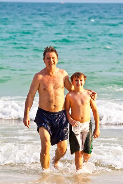 Far och son på den vackra sandstranden — Stockfoto