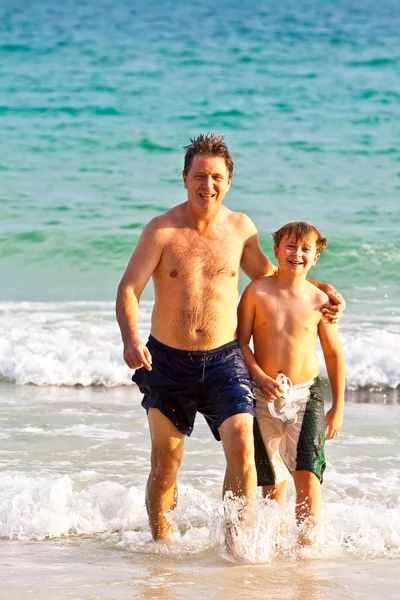 Otec a syn na krásné písečné pláži — Stock fotografie