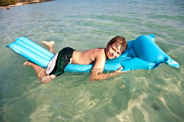 Мальчик наслаждается кристально чистой водой в океане — стоковое фото
