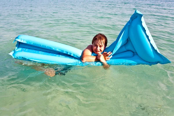 Menino gosta do colchão de ar no mar — Fotografia de Stock