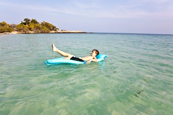 Pojken har air madrass i havet — Stockfoto
