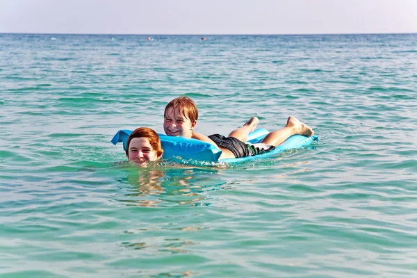 Bracia cieszyć się grać razem w krystalicznie czysty ocean — Zdjęcie stockowe