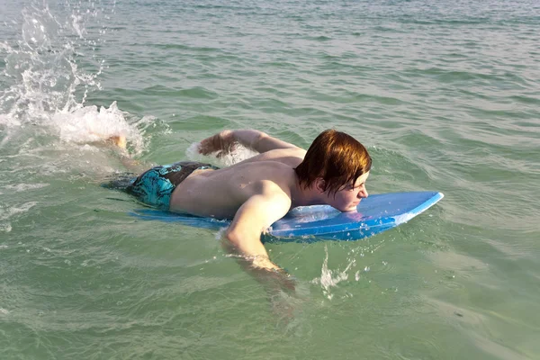 Мальчику нравится заниматься серфингом в океане — стоковое фото