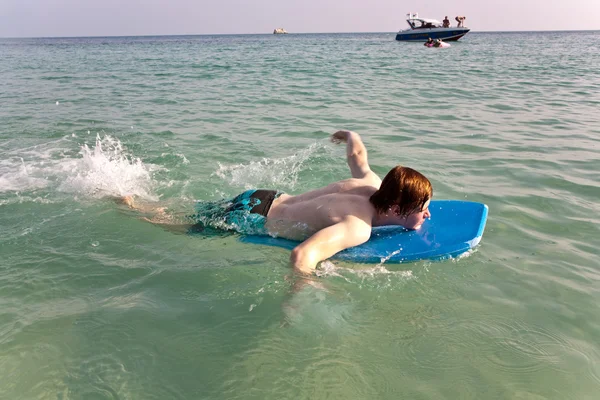 Chlapec se těší surfování v oceánu — Stock fotografie