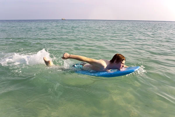 Chlapec se těší surfování v oceánu — Stock fotografie