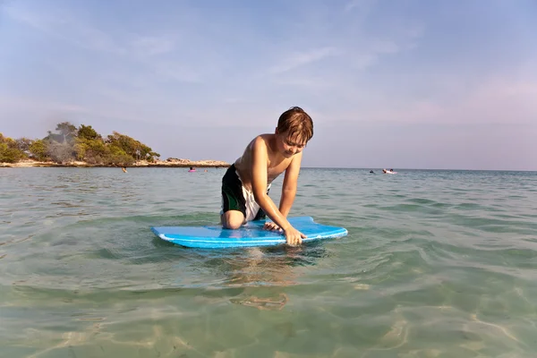 Pojken har surfing i havet — Stockfoto