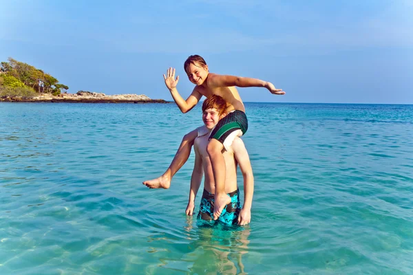 Bratři spolu hrají pickapack v krásné oceánu — Stock fotografie