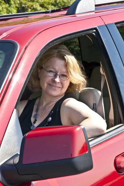 웃는 여자는 빨간 자동차 드라이브 — 스톡 사진