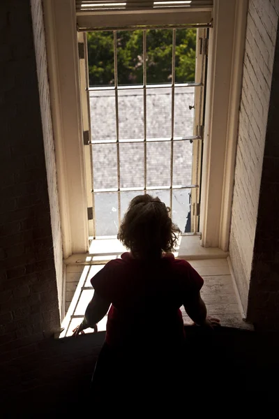 Γυναίκα που ψάχνει έξω από ένα παράθυρο — Φωτογραφία Αρχείου