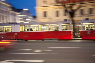 Red old trolley car in Vienna in the first District by night clipart