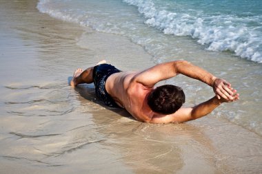 Man lying at the beach clipart