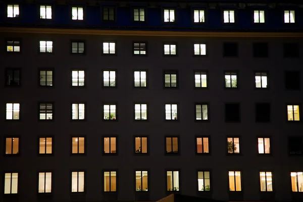 Janelas de uma casa de negócios com luz à noite — Fotografia de Stock