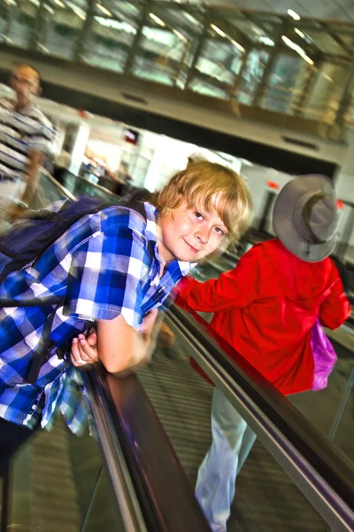 Young boy on a moving staircase inside the airport — Stock Photo, Image