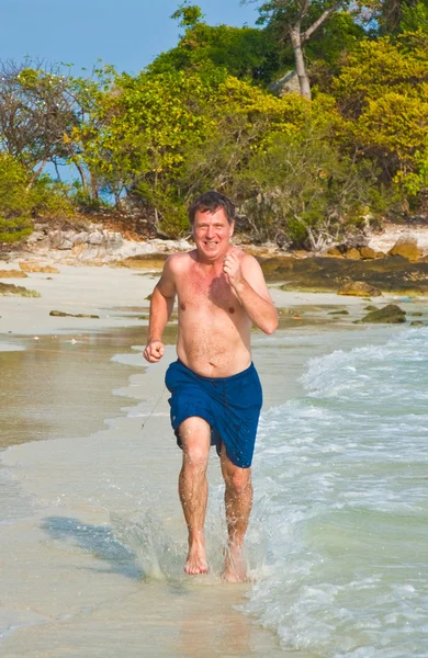 Άνθρωπος που τρέχει κατά μήκος της όμορφης παραλίας — Φωτογραφία Αρχείου
