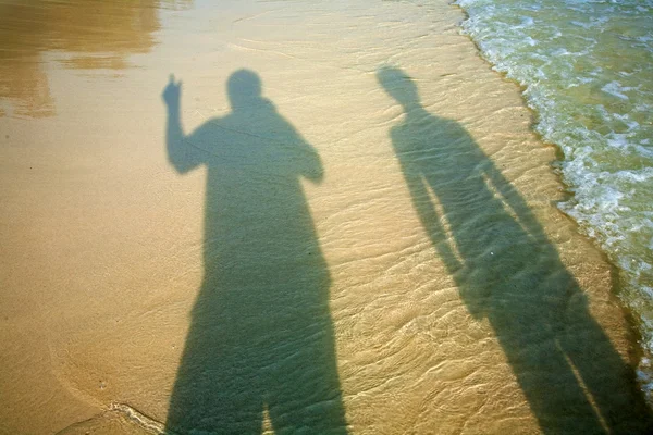Тень отца и сына на пляже — стоковое фото