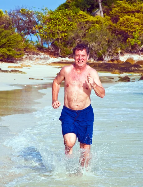 L'uomo corre lungo la bellissima spiaggia — Foto Stock