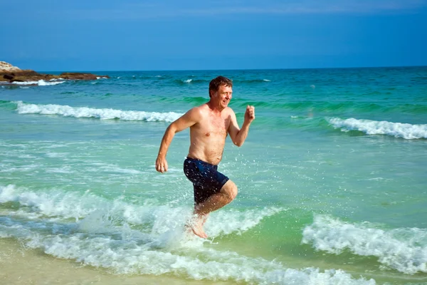 Man is running along the beautiful beach — Stock Photo, Image