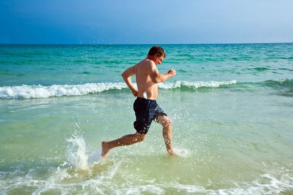 Άνθρωπος που τρέχει κατά μήκος της όμορφης παραλίας — Φωτογραφία Αρχείου