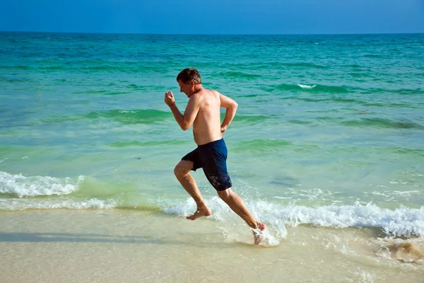 L'homme court le long de la belle plage — Photo